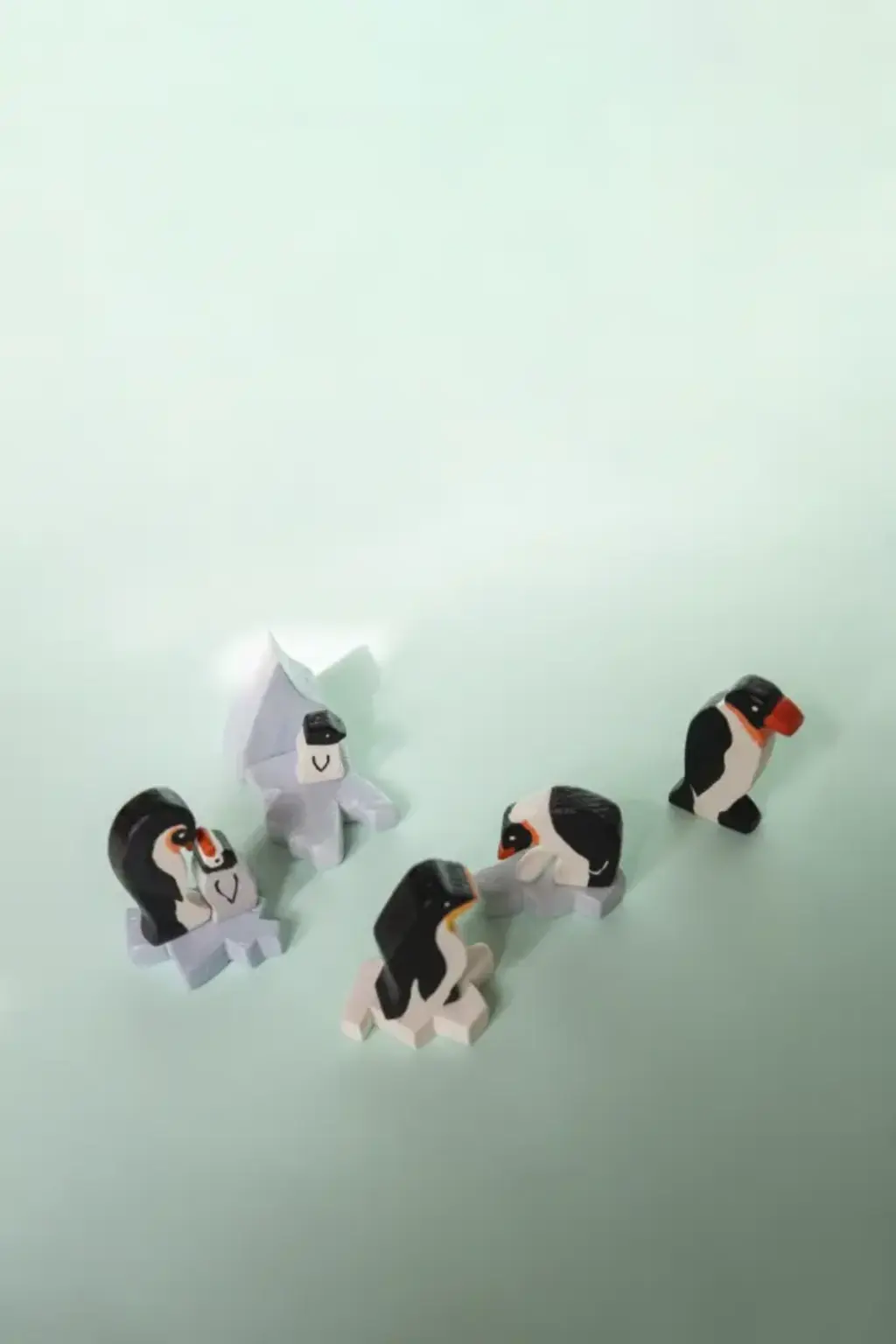 pinguine1 Viele kleine Pinguine und Eisschollen aus Holz stehen nebeneinander.