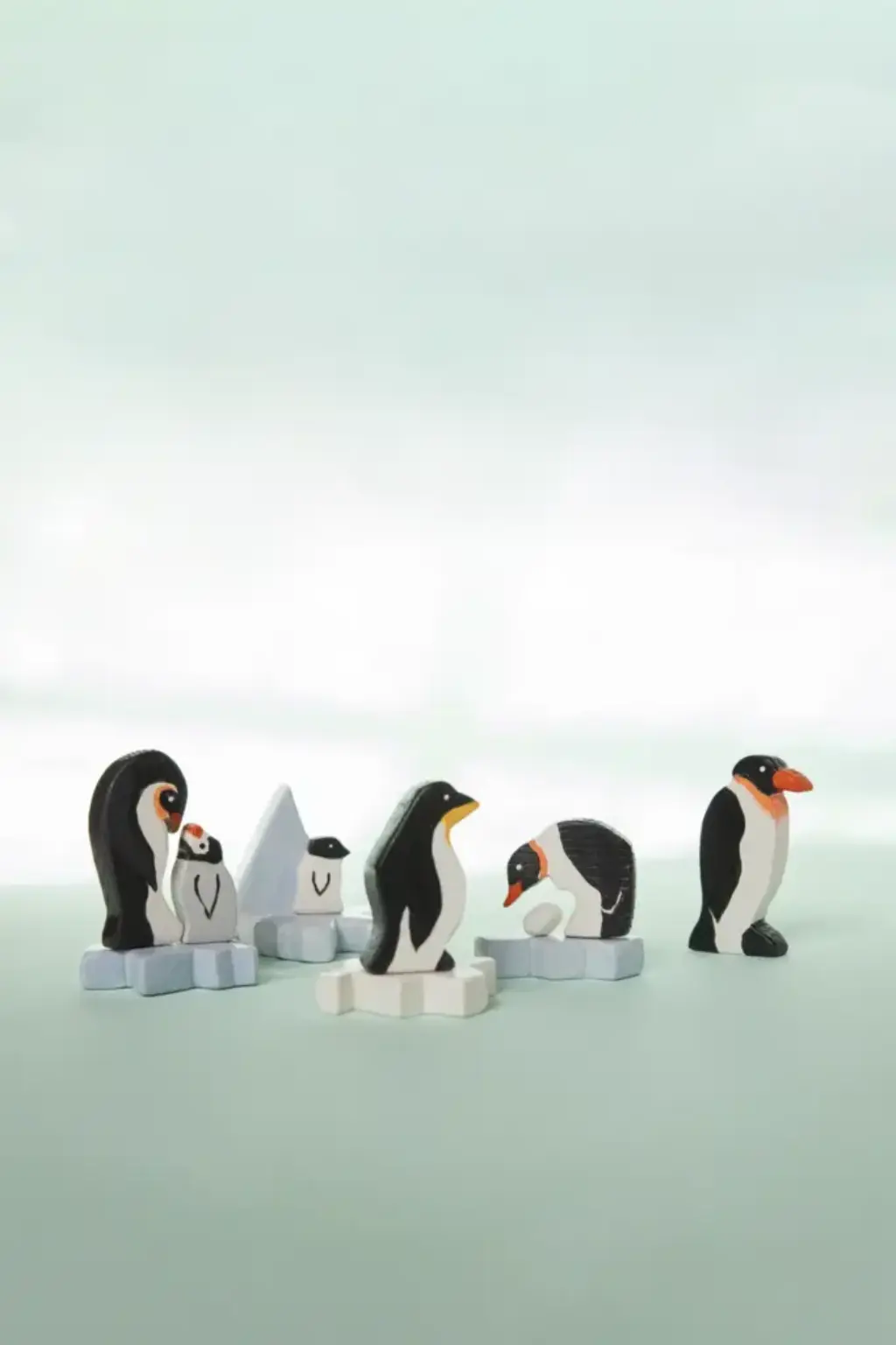 pinguine2 Viele kleine Pinguine und Eisschollen aus Holz stehen nebeneinander.