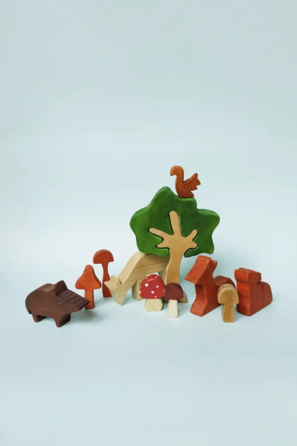 waldtiere4 Mehrere kleine Holzfiguren (Wildschwein, Rehe, Pilze, Baum und Eichhörnchen) nebeneinander.