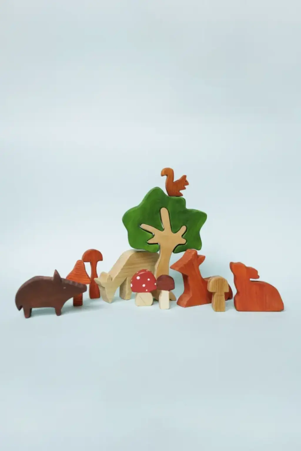 waldtiere7 Mehrere kleine Holzfiguren (Wildschwein, Rehe, Pilze, Baum und Eichhörnchen) nebeneinander.
